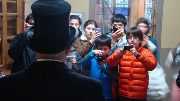 Grupo con niños y niñas fotografiando a una persona vestida de época