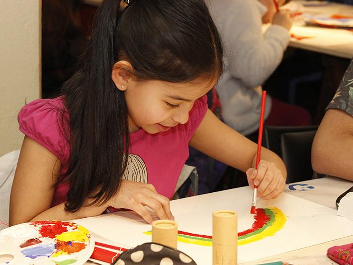 Niña pintando su trabajo