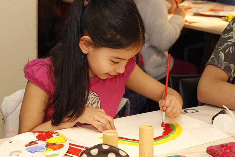Niña pintando su trabajo